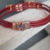 Bracelet femme en cuir rond rouge et passants roses dorés