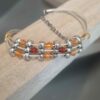 Bracelet femme, ado en cuir rond 0,8mm or, passants argentés et perles rouges et oranges
