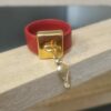 Bague en cuir rouge cousu et bélière carrée dorée avec pampille oiseau