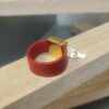 Bague en cuir rouge cousu et bélière carrée dorée avec pampille oiseau