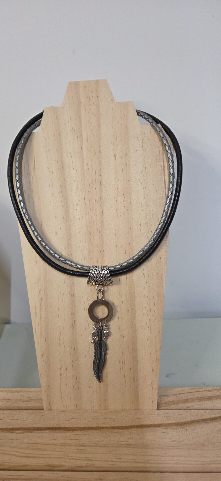 Collier femme cuir tressé argenté et rond noir, pendentif plume noire et passants argentés