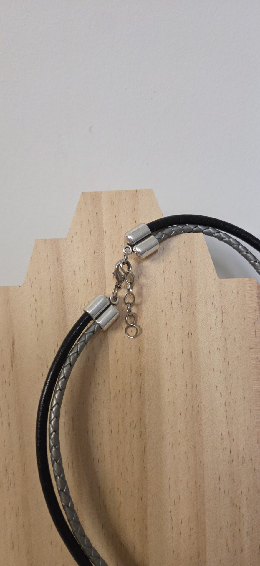 Collier femme cuir tressé argenté et rond noir, pendentif plume noire et passants argentés